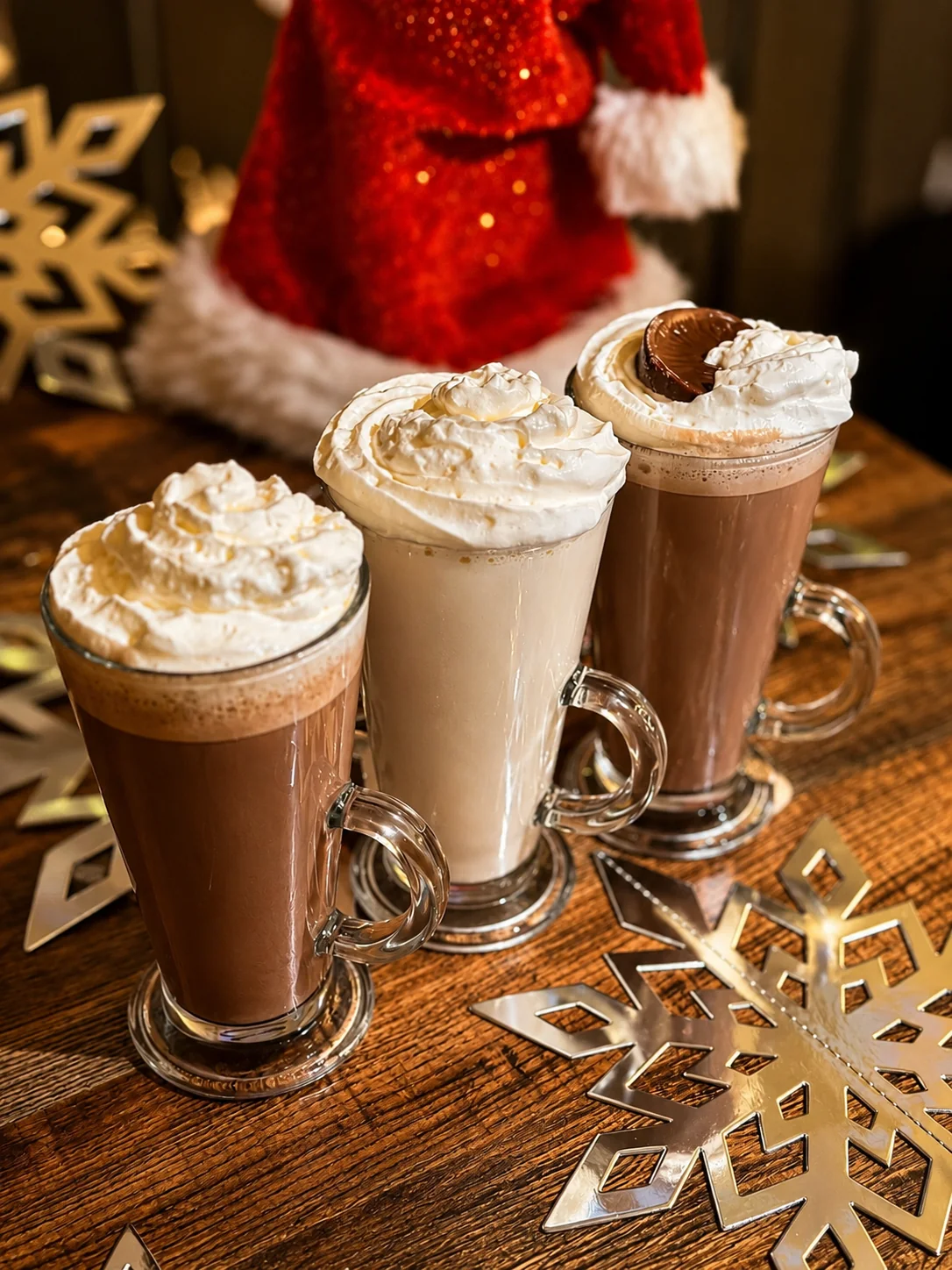 Three festive hot chocolates topped with whipped cream