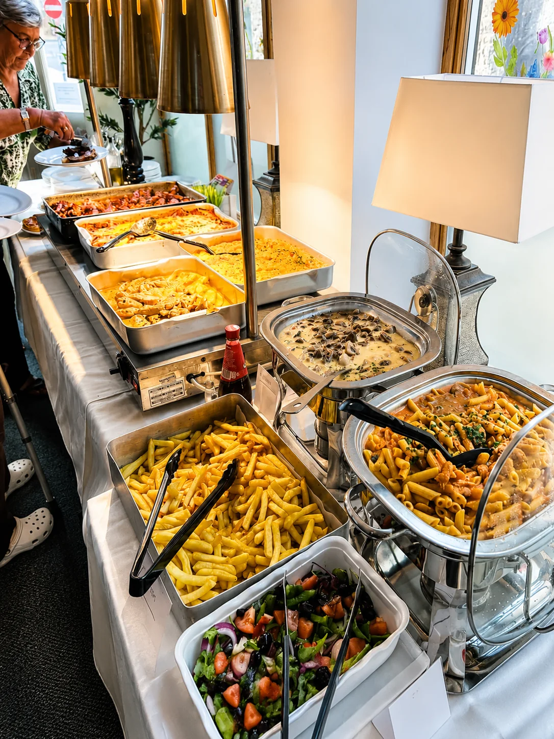 A buffet of pasta, sauces and salad ready to serve