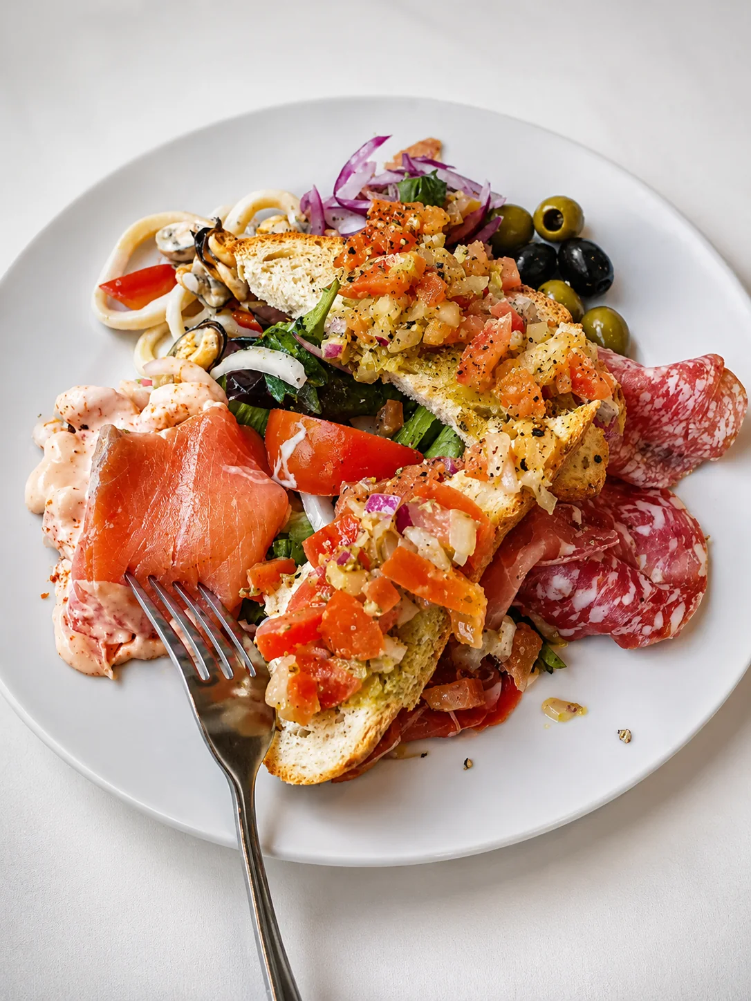 A seafood and antipasti platter with prawns, mussels, olives and bruschetta